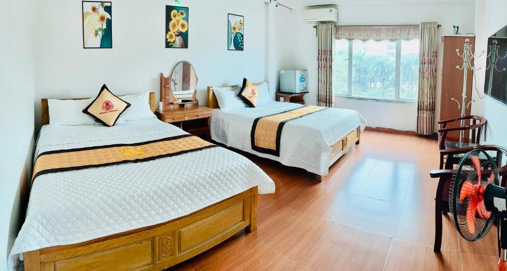 Van Anh Hotel في Noi Bai: غرفة نوم بسريرين ومرآة
