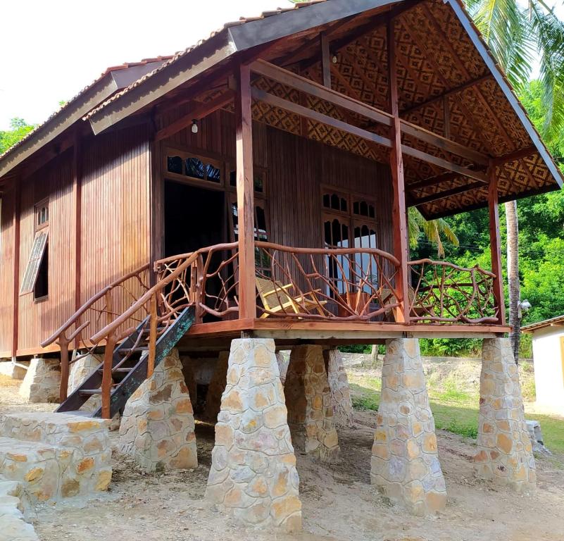 un pequeño edificio con porche y escalera en Eco Casa, en Karimunjawa