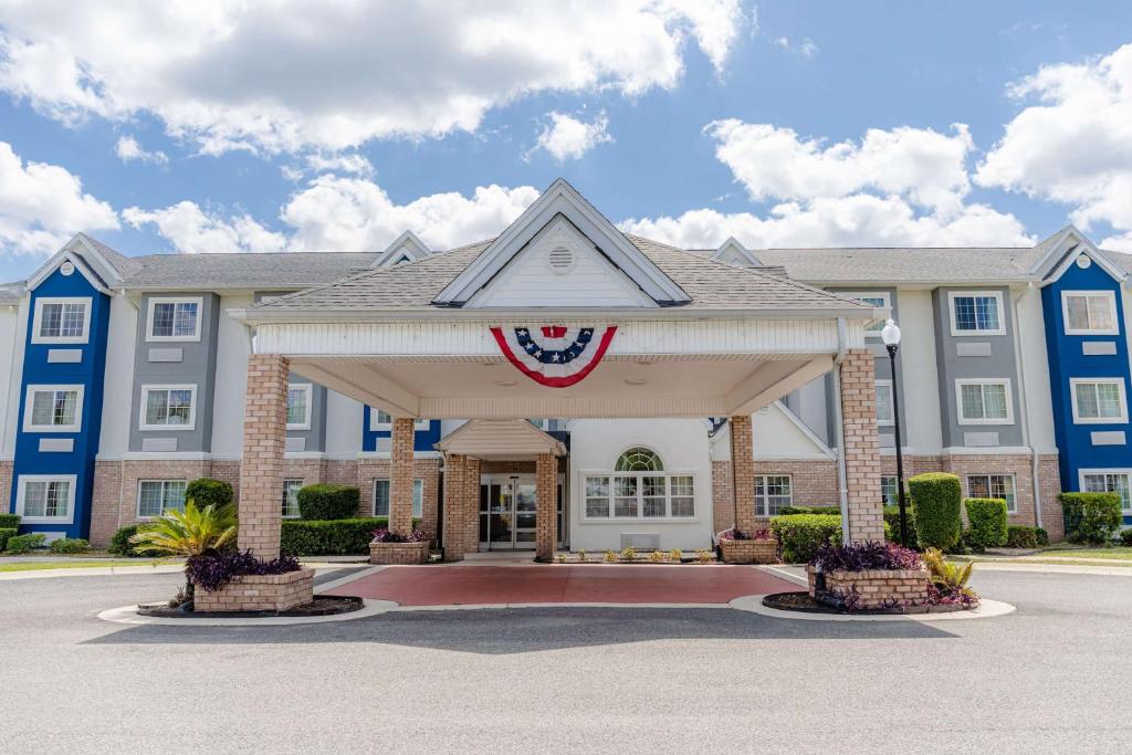 a inn with an american flag on the front at Microtel Inn & Suites by Wyndham Kingsland Naval Base I-95 in Kingsland