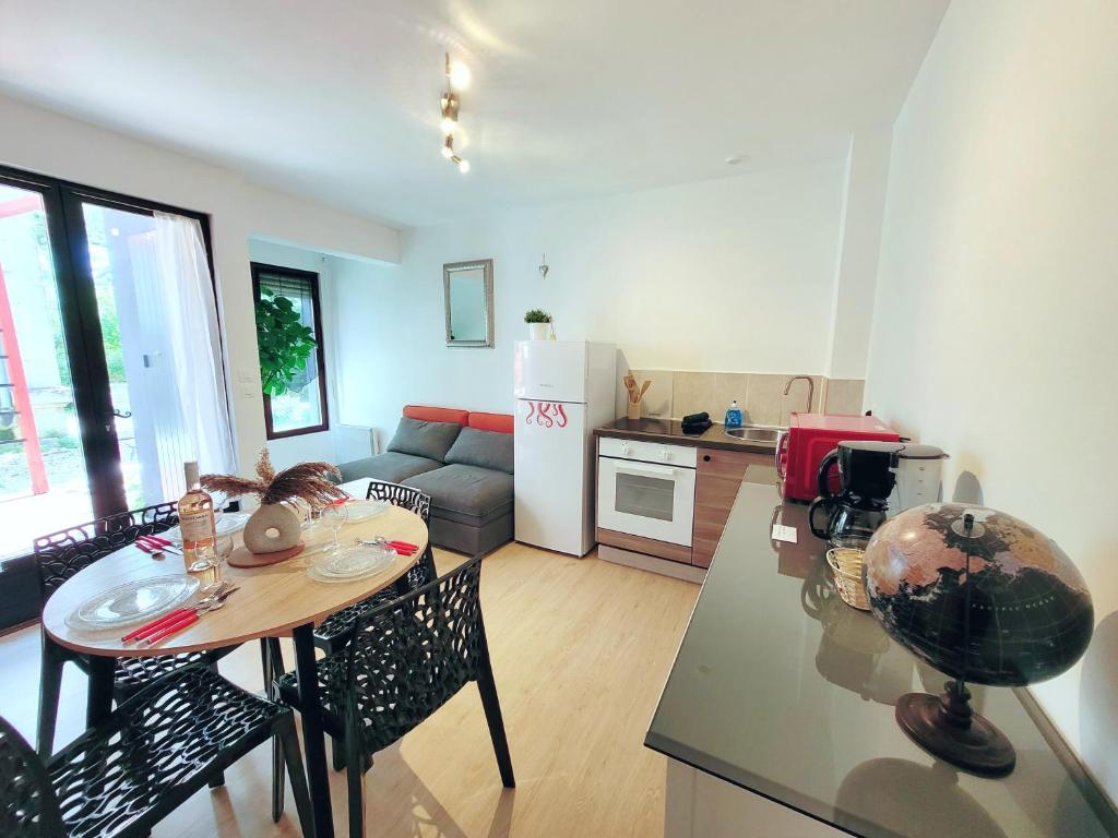 une cuisine et un salon avec une table et un comptoir dans l'établissement Appartement 2 chambres centre-ville avec terrasse, à La Rochelle
