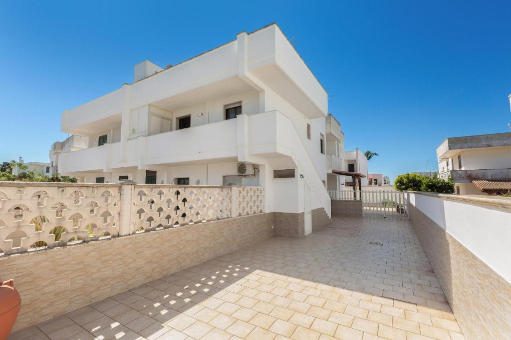 a white house with a fence in front of it at Casa di Tosca by BarbarHouse in Torre dell'Orso