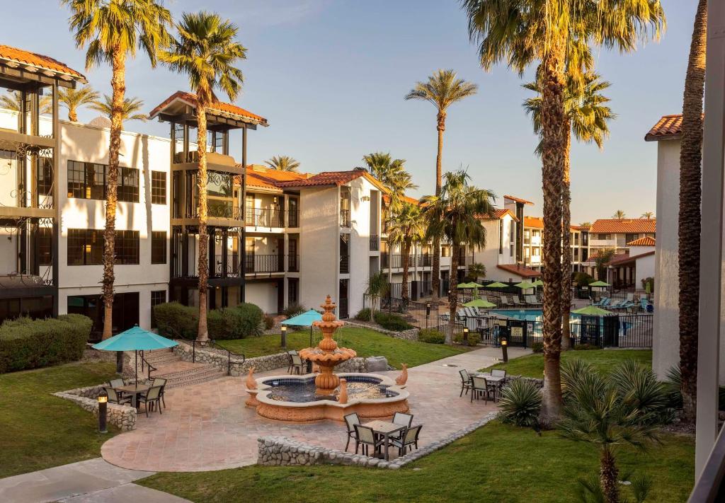 un patio con una fuente y palmeras en Embassy Suites by Hilton Palm Desert, en Palm Desert