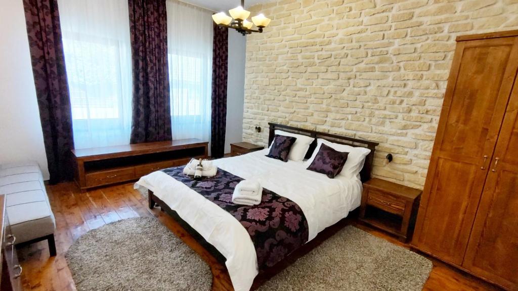 a bedroom with a bed and a brick wall at Casa Romana in Turda