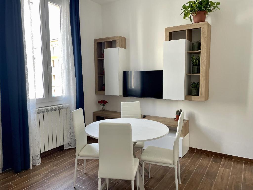 a dining room with a white table and white chairs at Casa Curcio in Bologna