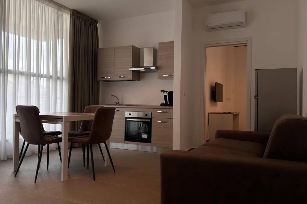 a kitchen and living room with a table and chairs at CconfortHotels Puglia Promenade Apartment 3 in Bari