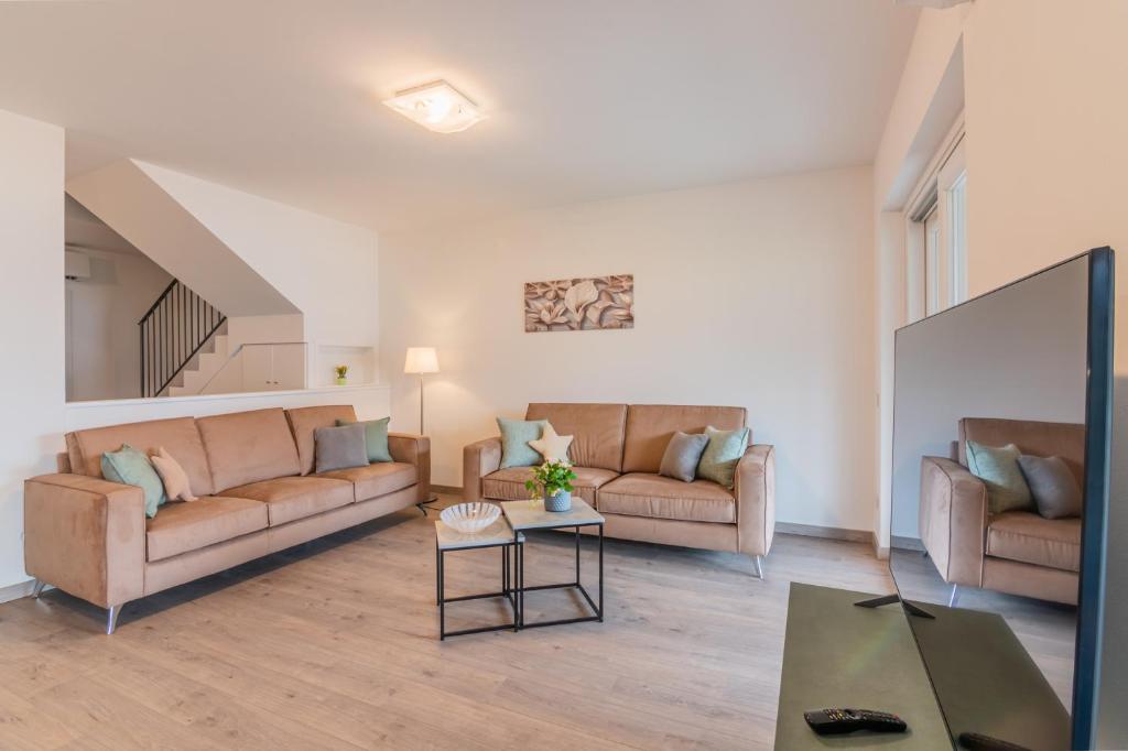 un salon avec deux canapés et une table dans l'établissement VILLA DEI VENTI - BREVA by Curtiaffitti, à Pianello Del Lario