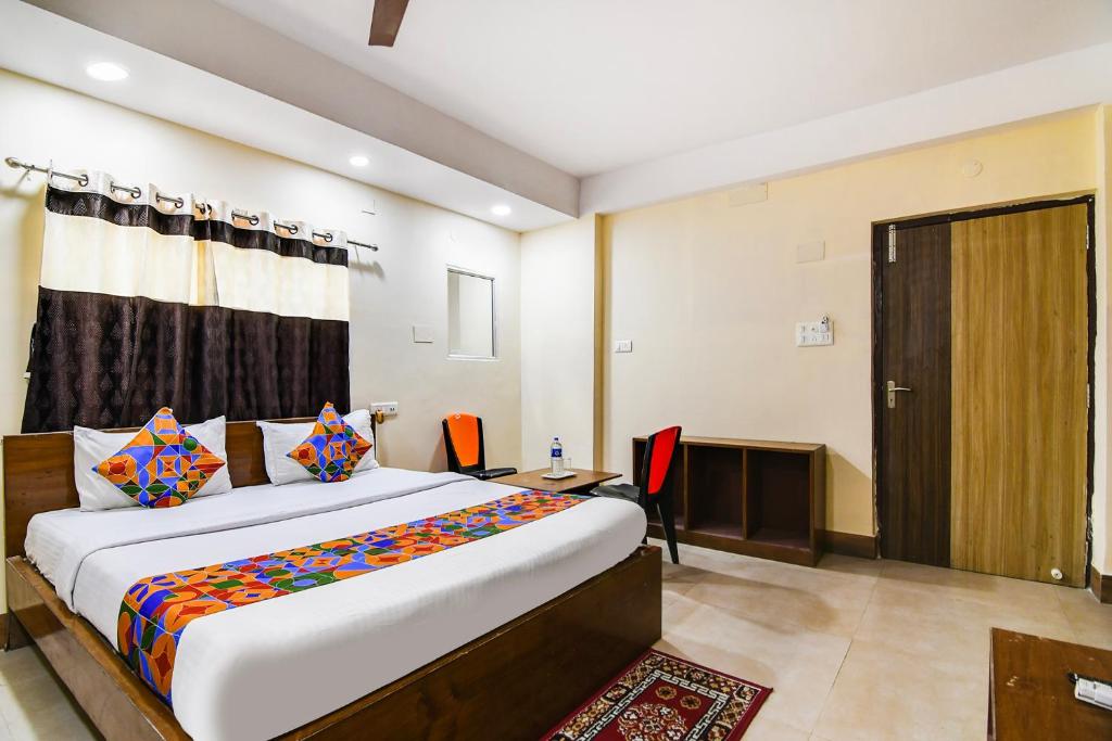 a bedroom with a bed and a desk and a door at FabHotel Ridz Inn in Salua