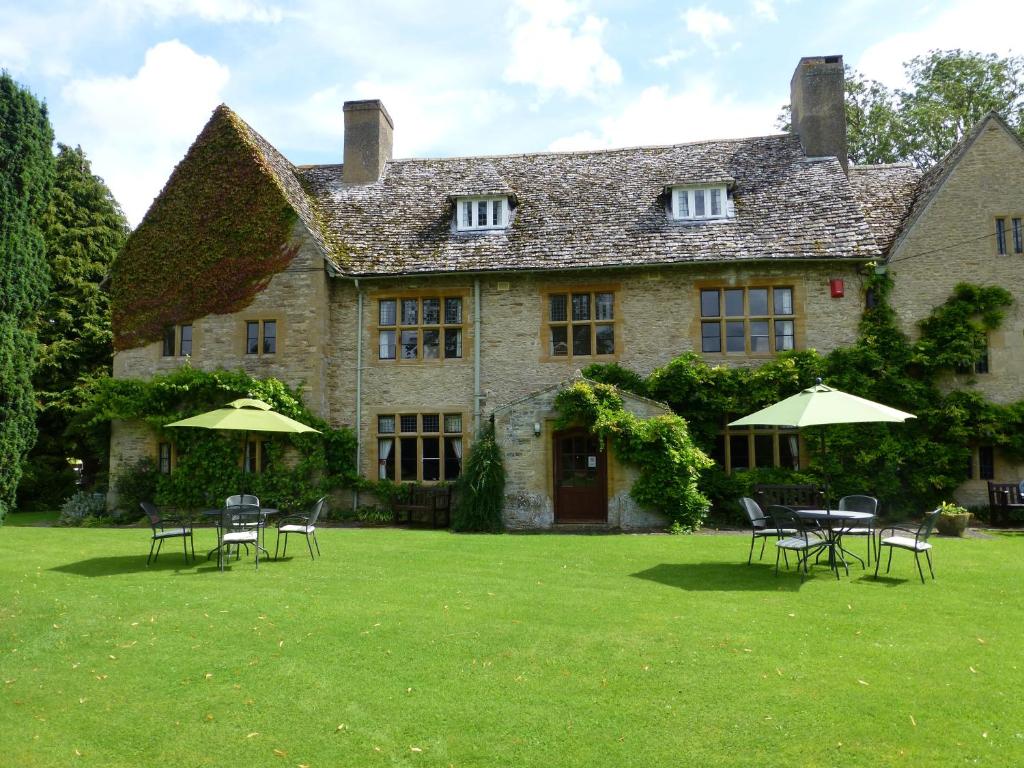 a large stone house with chairs and umbrellas in the yard at Charney Manor in Kingston Bagpuze