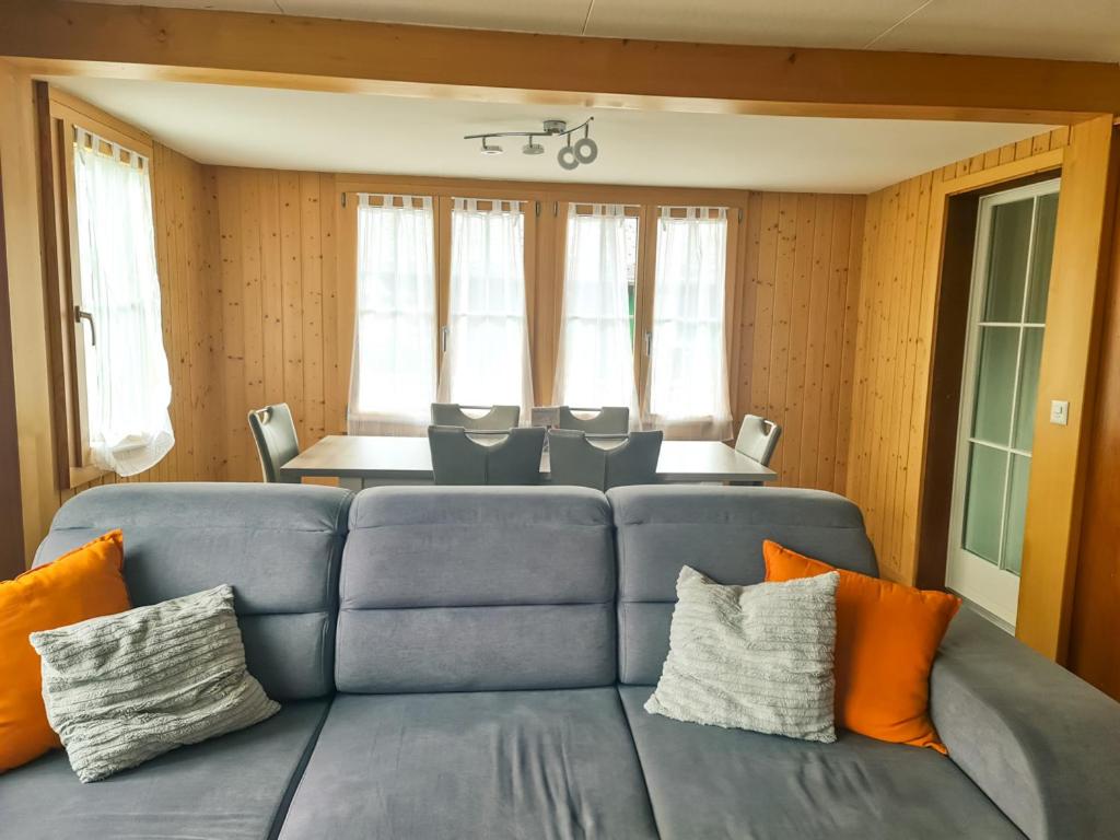 a living room with a blue couch with orange pillows at Abendberg - zentral nähe Bahnhof in Wilderswil