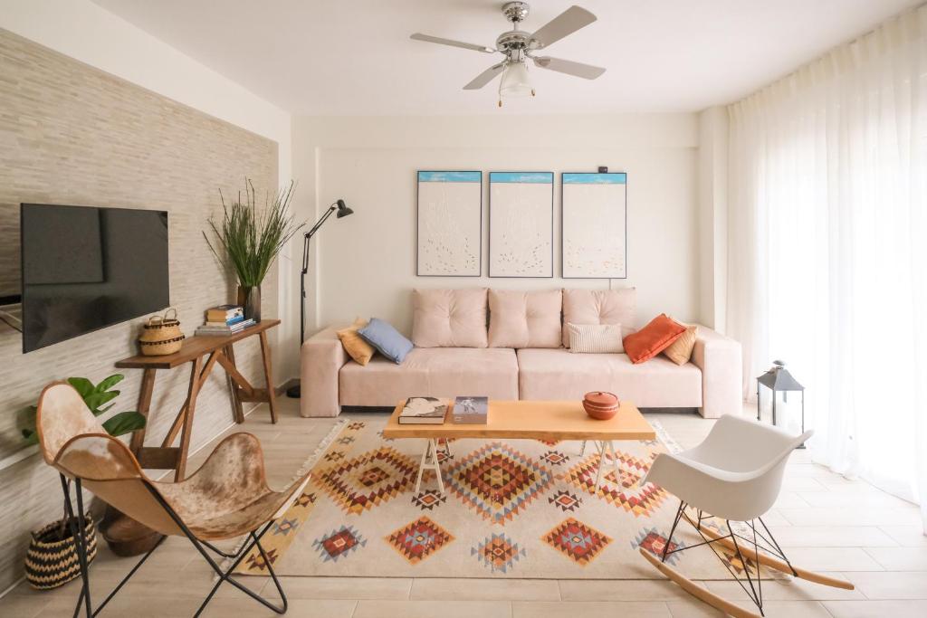 una sala de estar con un sofá y una mesa en Sani Eclectic Family Villa, private garden, en Sani Beach