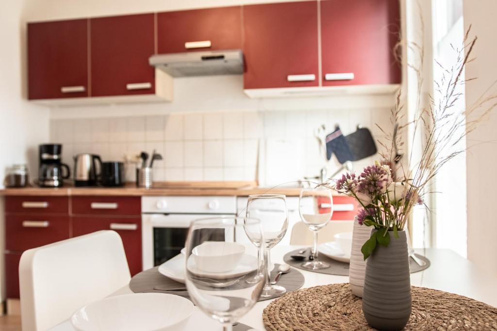 a kitchen with red cabinets and a table with wine glasses at EM- Football home of Azzurri centrally with balcony and parkspace in Iserlohn