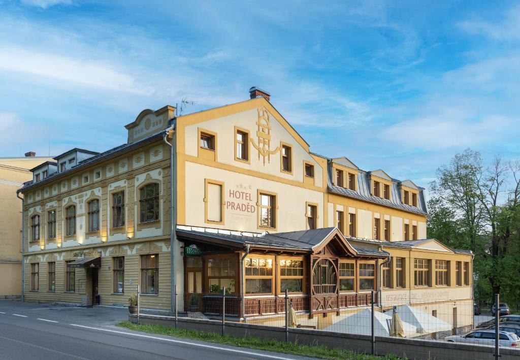 un grand bâtiment jaune sur le côté d'une rue dans l'établissement Hotel Praděd Thamm, à Zlaté Hory