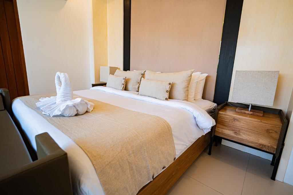 een slaapkamer met een groot bed en een tafel met een lamp bij La Boutique villas Seminyak Bali in Seminyak