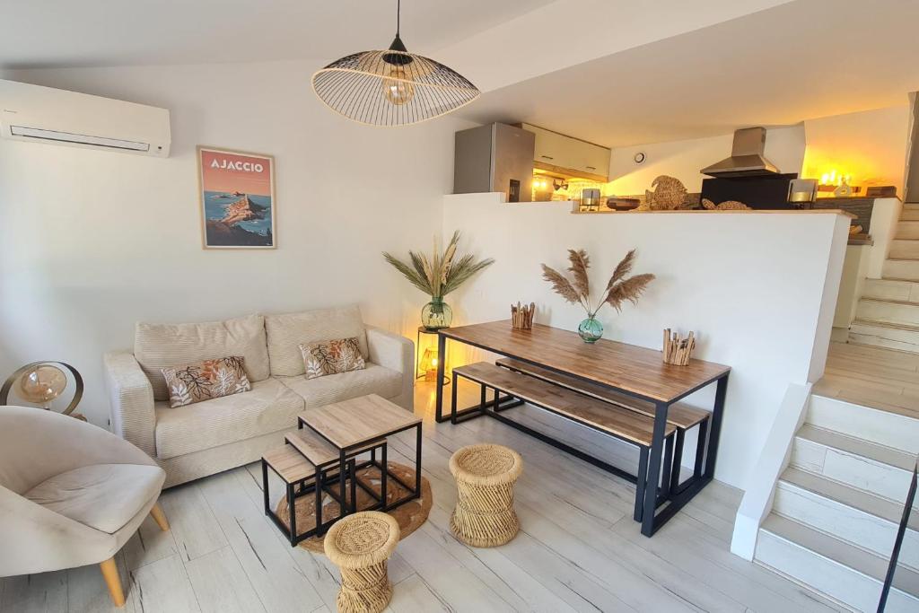 un soggiorno con un tavolo e un divano di Charming house with terrace and pool a Porticcio
