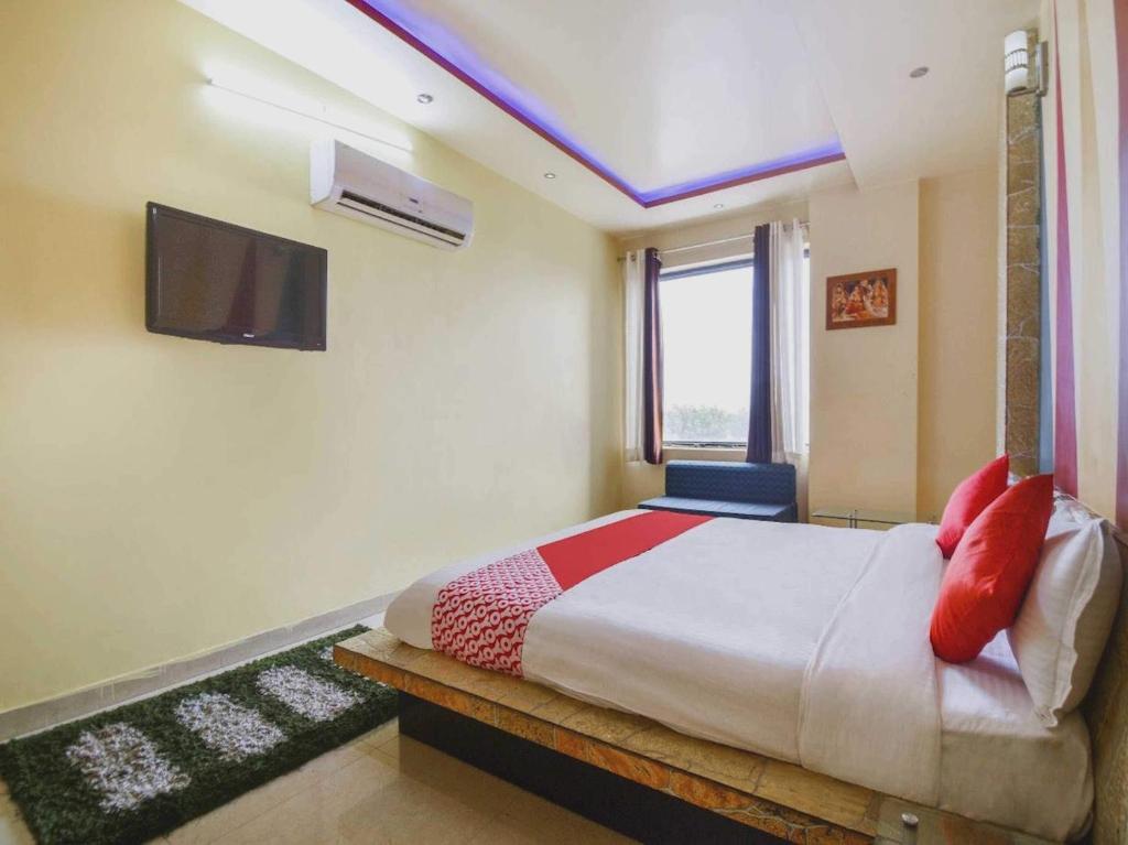 - une chambre avec un lit et une télévision murale dans l'établissement 7R Resort, à Jaipur