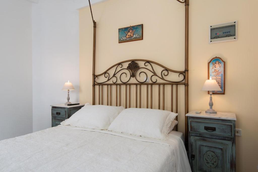 a bedroom with a large white bed with two night stands at Villa Areto in Kamares