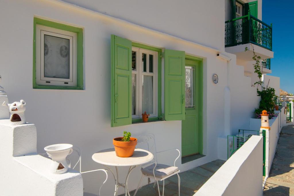 a building with green doors and a table and chairs at Villa Areto in Kamares
