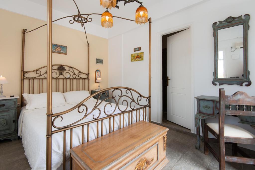 a bedroom with a canopy bed with a desk and a mirror at Villa Areto in Kamares