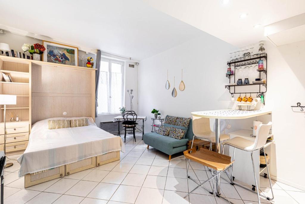 une chambre avec un lit et une table dans une pièce dans l'établissement GuestReady - Studio Confortable au centre de Paris, à Paris