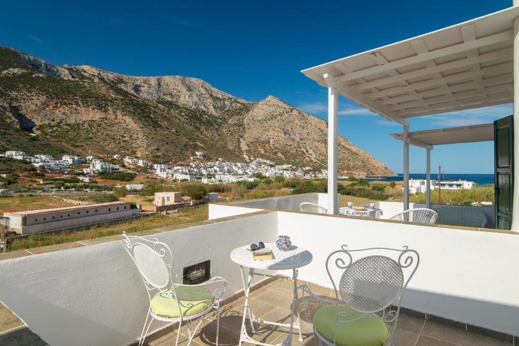 a table and chairs on a balcony with a mountain at Villa Areto in Kamares