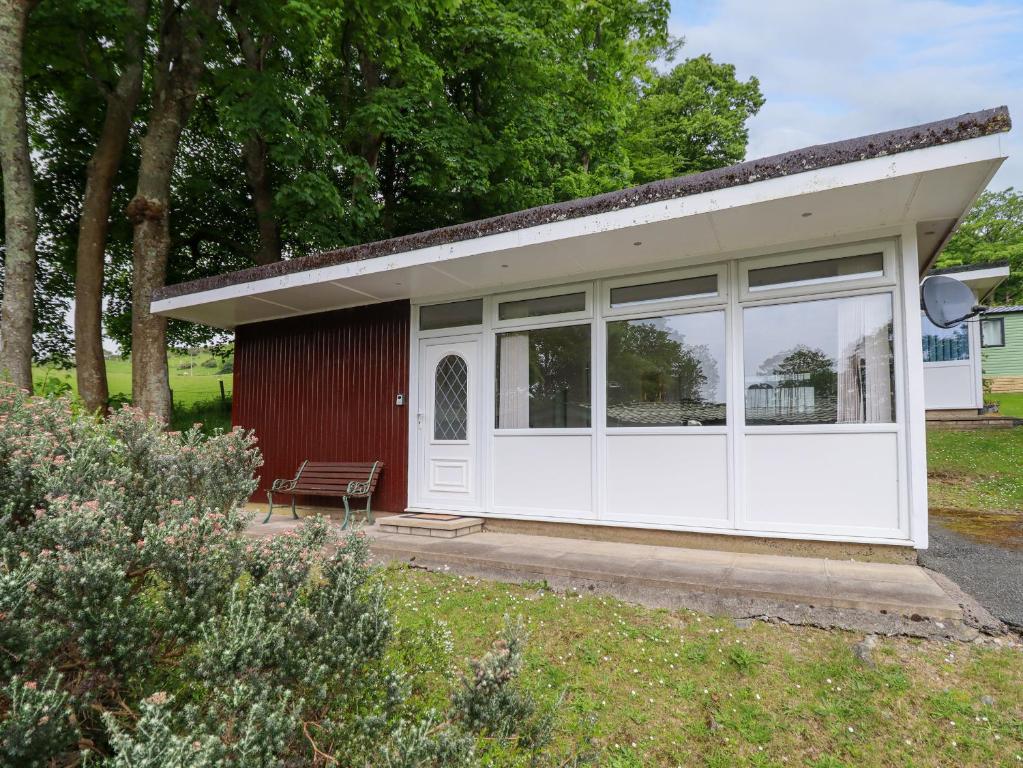 a detached garage with white doors and windows at Hill View in Tywyn