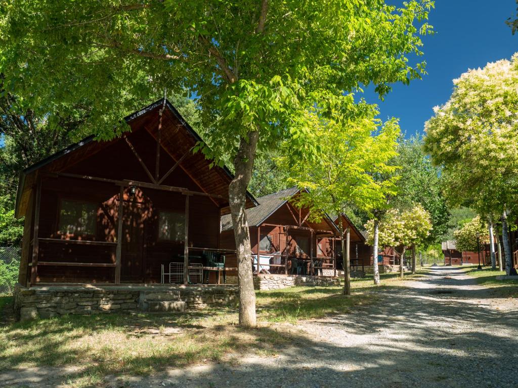 Un granero con un árbol delante en Centro de Vacaciones Morillo de Tou - Ainsa, en Aínsa