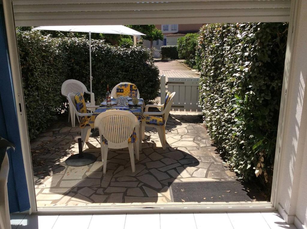 un patio avec une table, des chaises et un parasol dans l'établissement APPT 3 PIECES 44m2 + TERRASSE 14m2 REF 4039, à Le Castellas