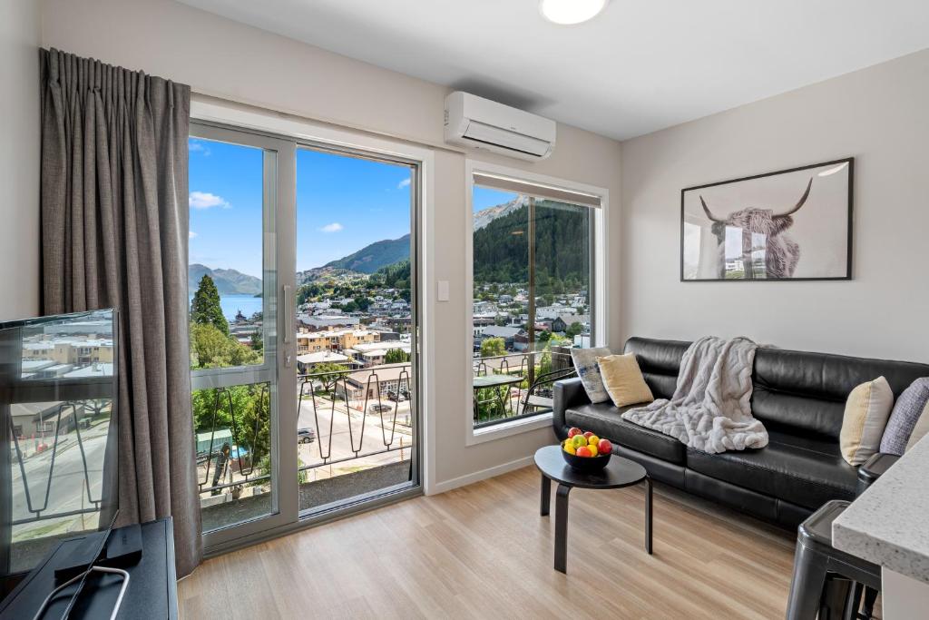 a living room with a couch and a large window at Central Location - 2 Bedroom Aptmt with Lake View in Queenstown