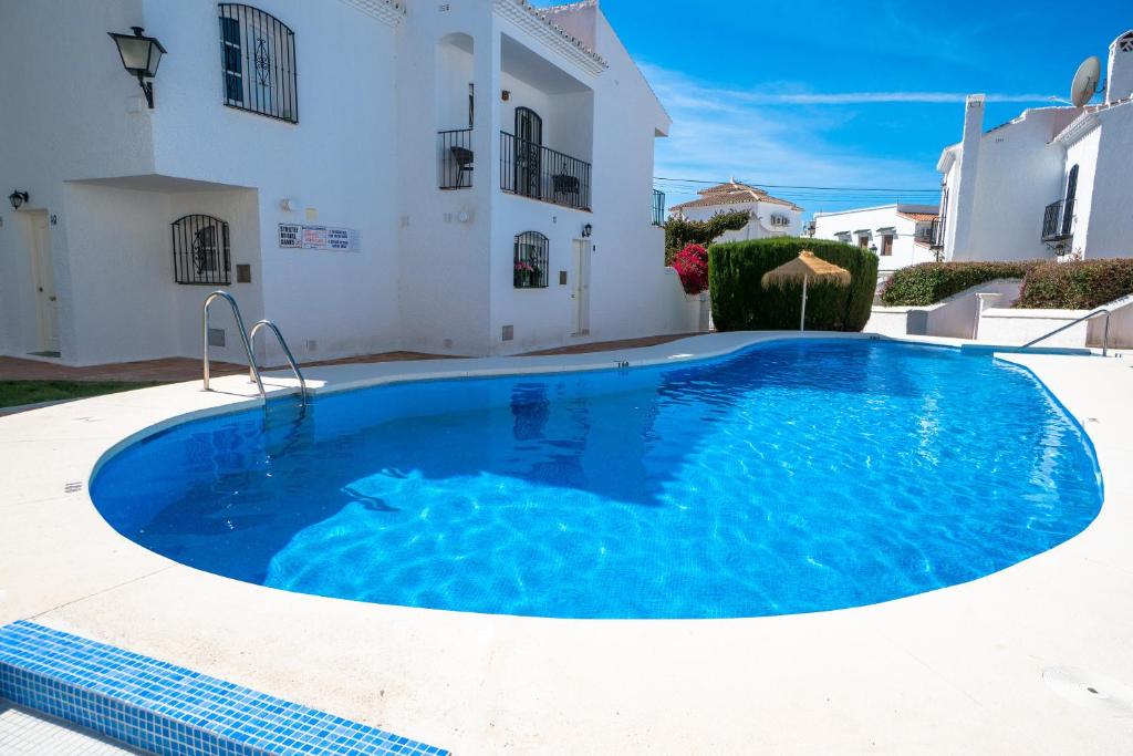 a large blue swimming pool in front of a house at PINOS 22 MENYBER in Nerja
