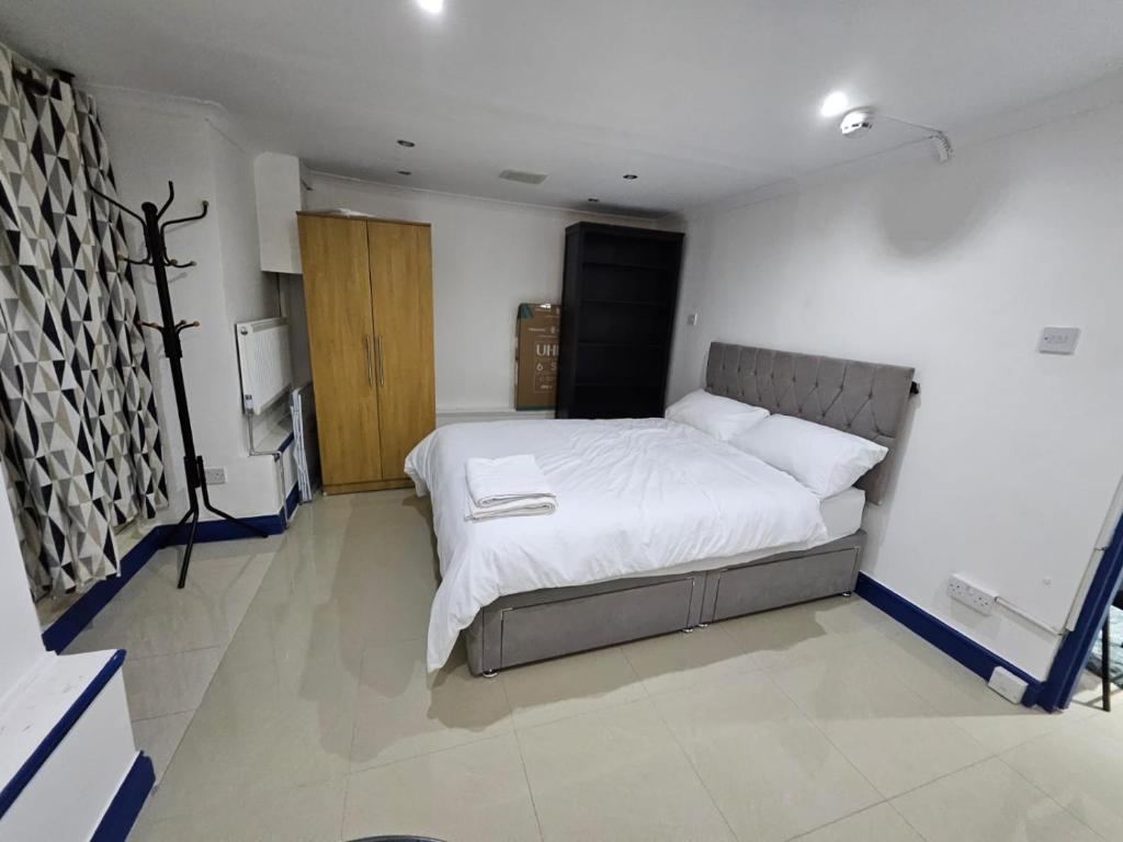 a bedroom with a large bed with white sheets at Savers Apartment Close to Emirates Stadium! in London