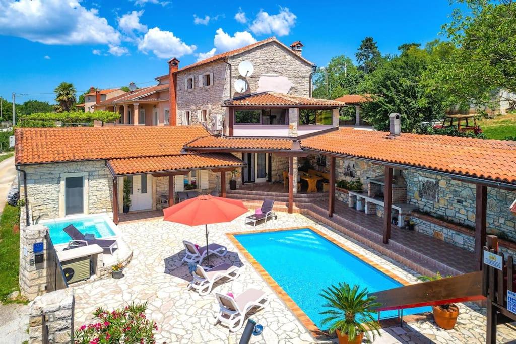 a home with a swimming pool and a house at Villa Antoli by IstriaLux in Bašići