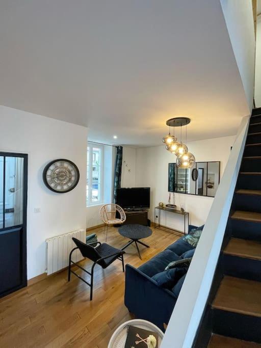 - un salon avec un canapé bleu et un escalier dans l'établissement Le Guiton - Maison avec terrasse, à La Rochelle