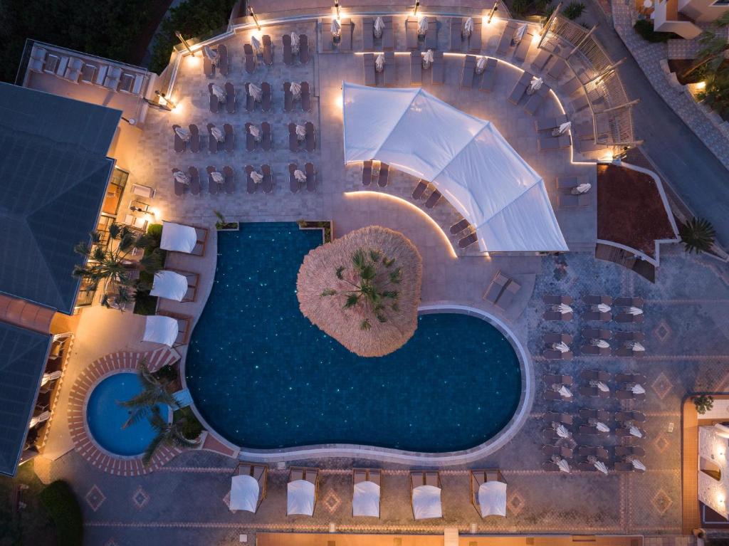 een uitzicht over het zwembad van het hotel met een parasol bij Asterias Village in Chersonissos