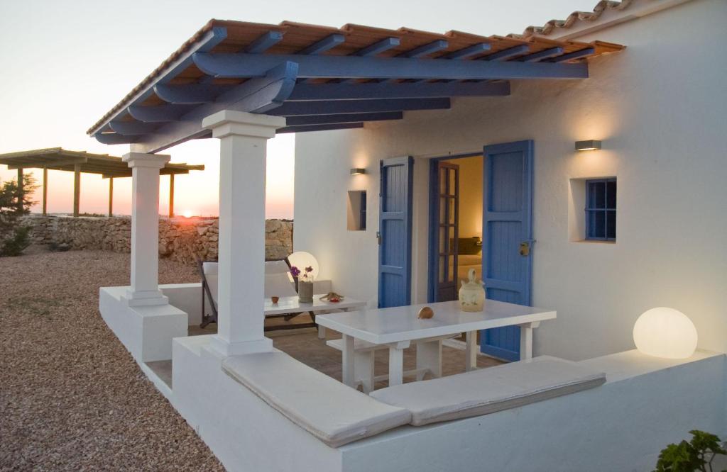 une maison blanche avec une porte bleue et une table dans l'établissement Cas Saliners - Villa Can Paya, à La Savina