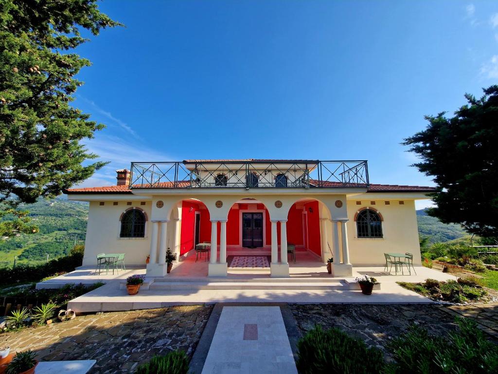 a house with red doors and a balcony at Domus Mare Cilento in Agropoli