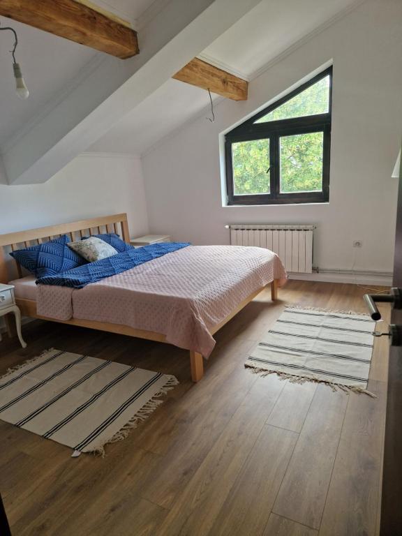 um quarto com uma cama e uma grande janela em Che Private Rooms Banovci em Novi Banovci