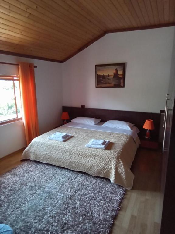ein Schlafzimmer mit einem Bett mit zwei Handtüchern darauf in der Unterkunft Eni's Villa in Lezha