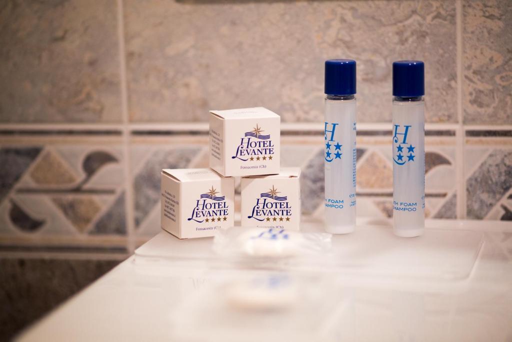 three bottles of liquid cleaner sitting on a bathroom counter at Hotel Levante in Fossacesia