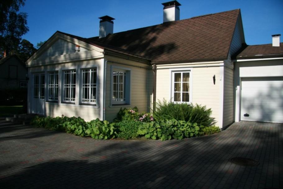 una pequeña casa blanca con garaje en Žubītes 8, en Jūrmala