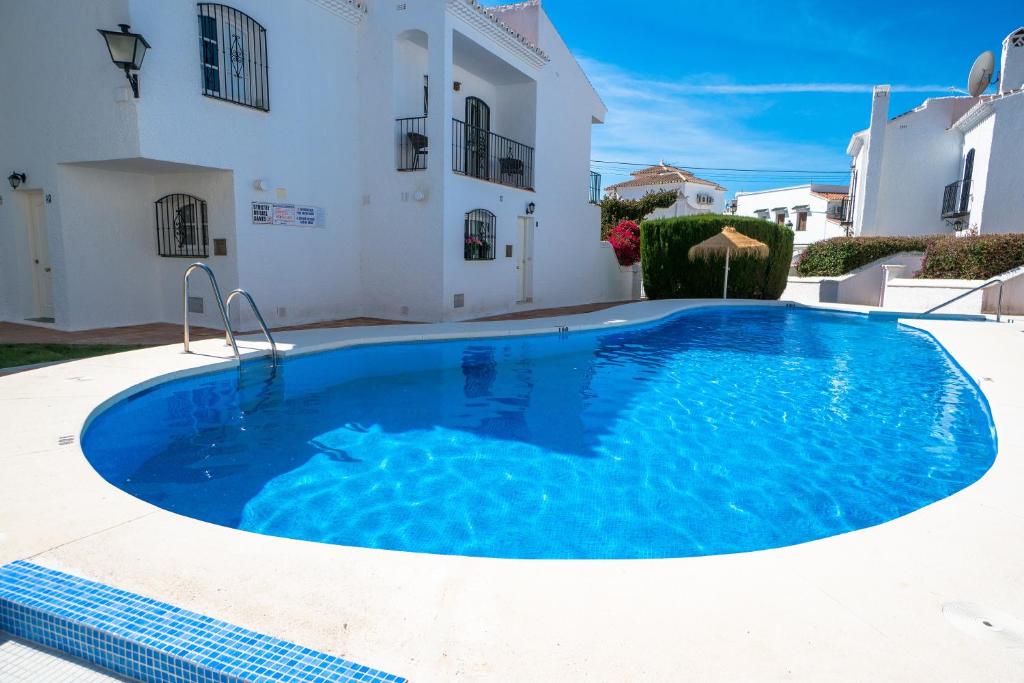 una grande piscina blu di fronte a una casa di PINOS 20 MENYBER a Nerja
