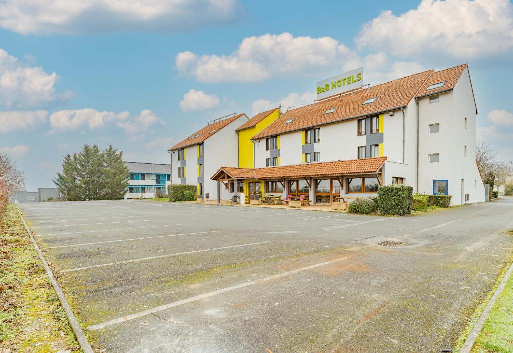 un parking vide en face d'un hôtel dans l'établissement B&B HOTEL Poitiers 3 Futuroscope, à Chasseneuil-du-Poitou