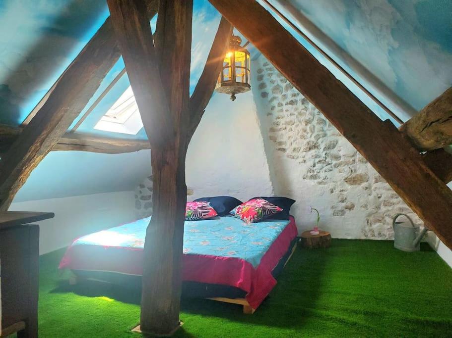 Un dormitorio con una cama en un ático en petite maison de village, en Ygrande