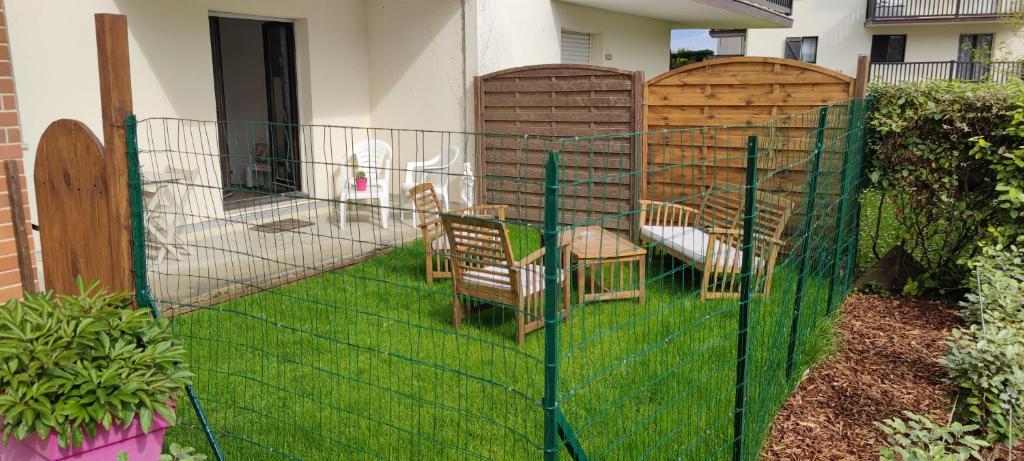 einen Metallzaun mit Stühlen im Hof in der Unterkunft Cabourg Plage in Cabourg