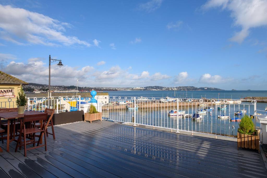 una terraza con mesa, sillas y puerto deportivo en Quayside View - Luxury Apartment on Paignton Harbour, en Paignton