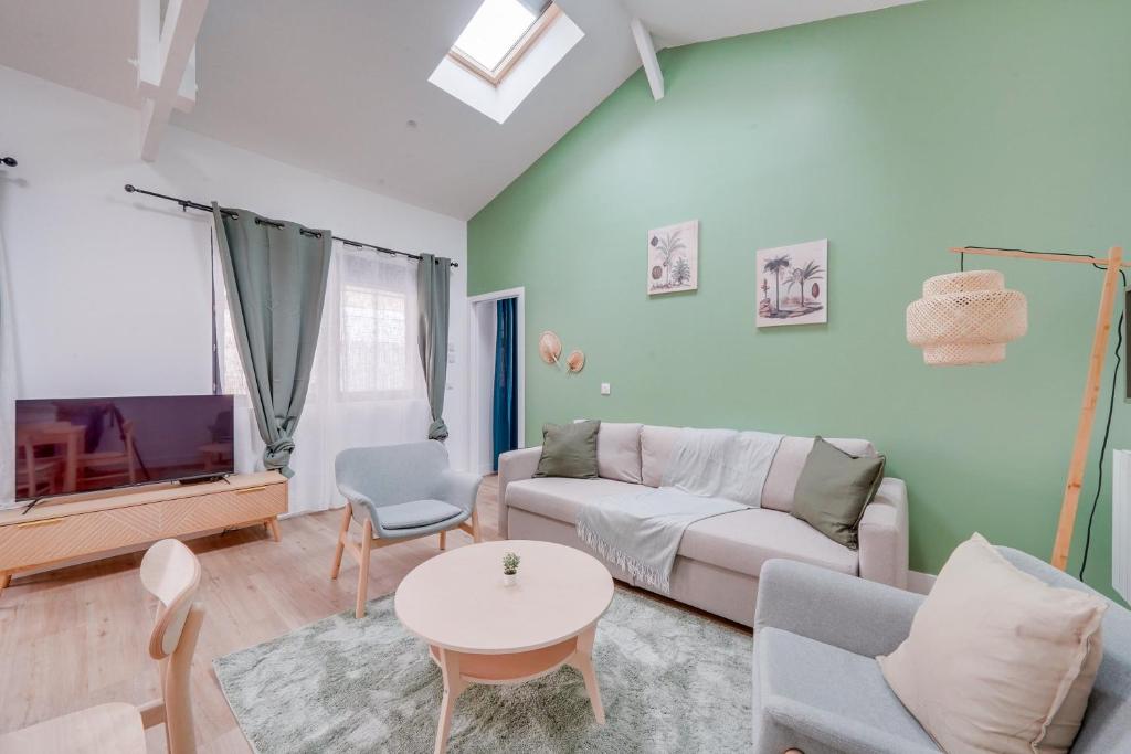 un salon avec un canapé, une table et une télévision dans l'établissement Le Rayon Vert - Appt dans le centre de Bordeaux, à Bordeaux