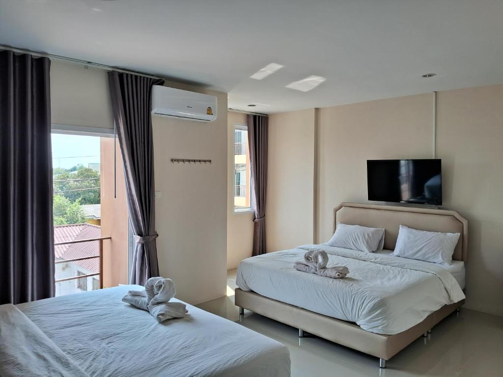 a bedroom with two beds with towels on them at เคทู เกสเฮาส์ (K2 Guesthouse) in Chon Buri