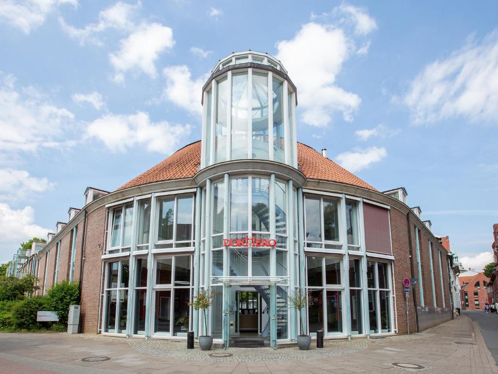 ein Gebäude mit einem Glasturm darüber in der Unterkunft Hotel Bargenturm in Lüneburg
