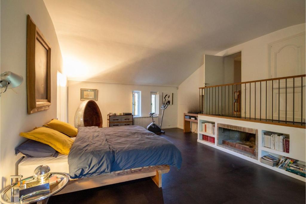 um quarto com uma cama grande e uma escada em La Grange Capelle em Villeneuve-lès-Avignon