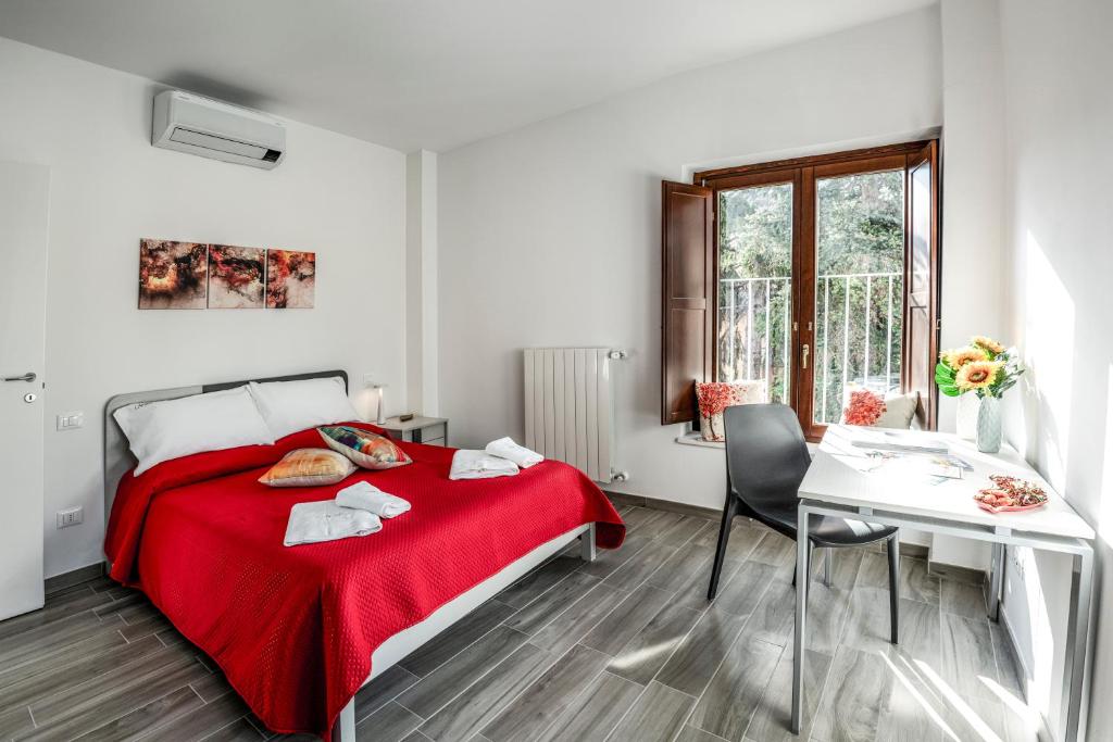 ラクイラにあるPosizione Top & Spazio - Il Tuo Apt 2 Camereの白いベッドルーム(赤いベッド1台、テーブル付)