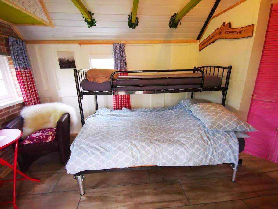 ein Schlafzimmer mit einem Etagenbett in einem Zimmer in der Unterkunft Trekkershut - Tiny House - Hikers cottage in Wijster
